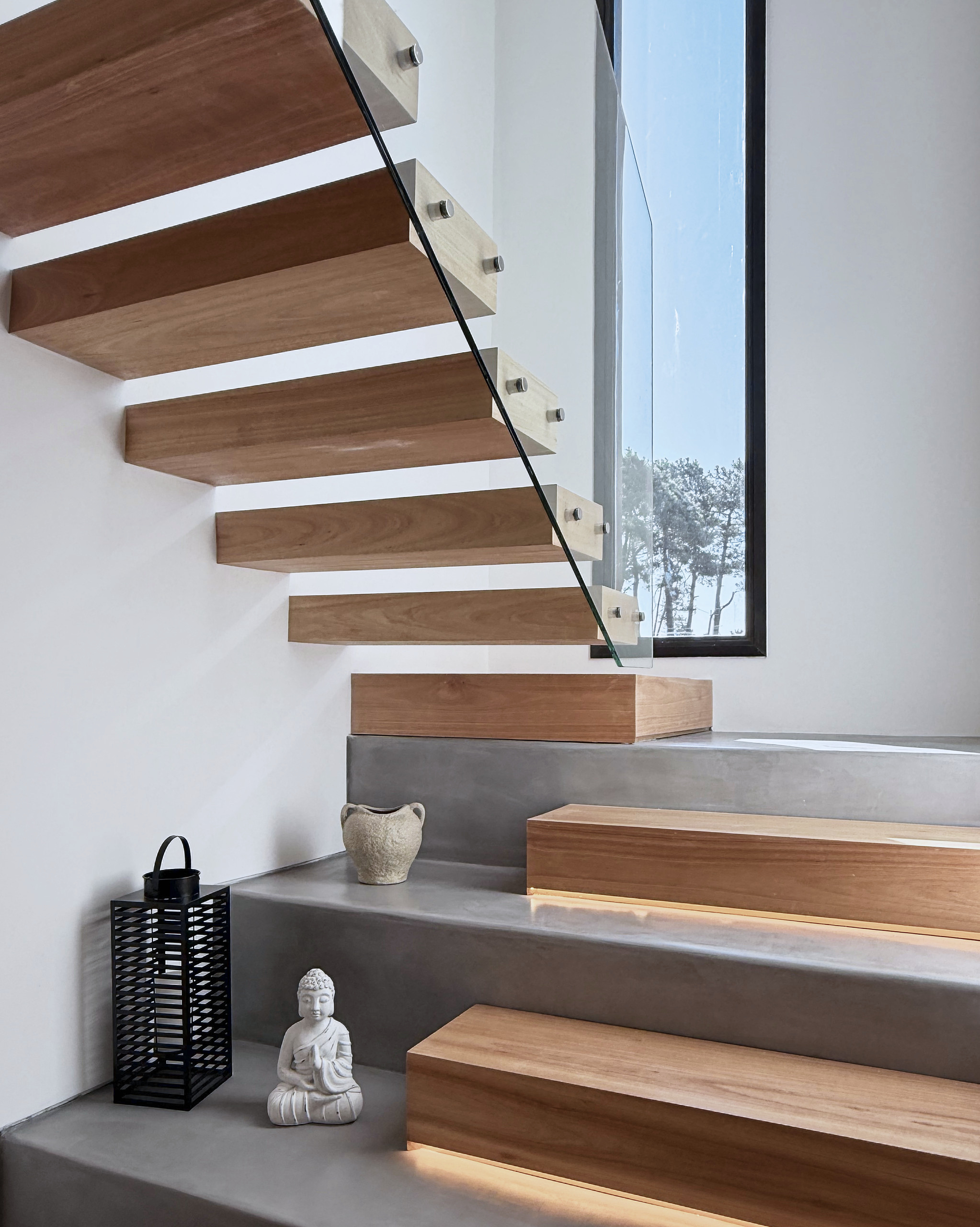 Escalera de madera, hormigón y baranda de vidrio