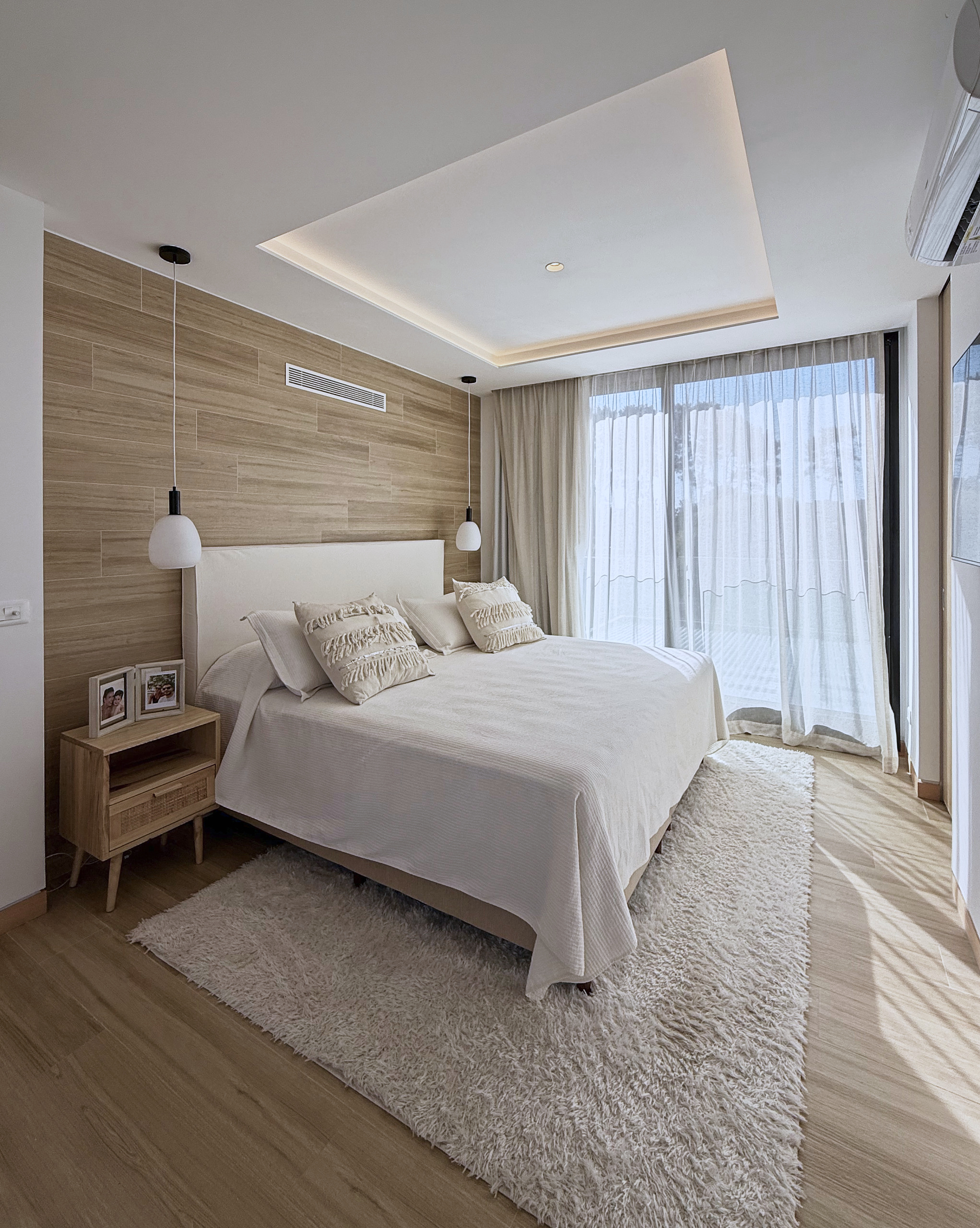 Dormitorio principal con madera clara e iluminación indirecta